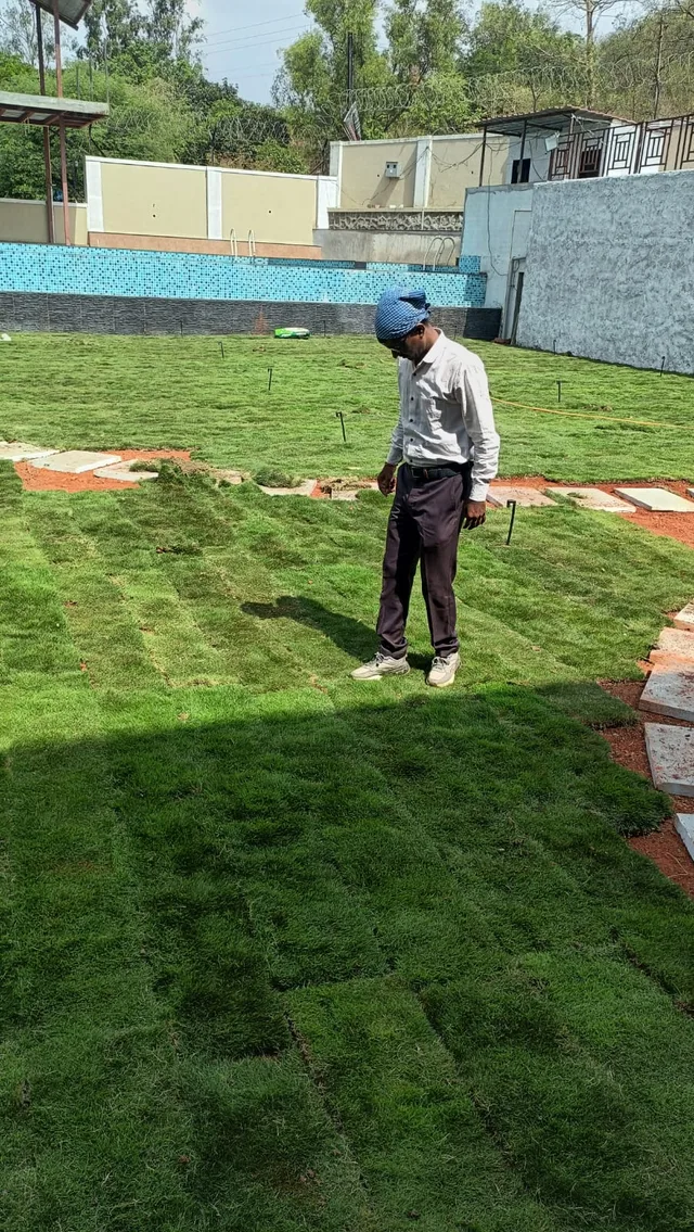 Person inspecting turf near a path